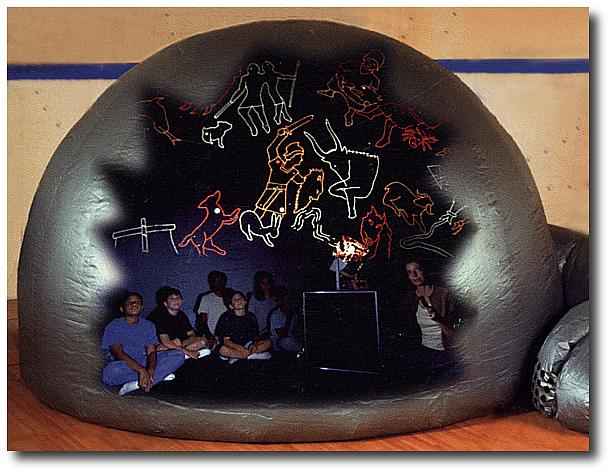 Students sit inside the inflatable STARLAB® dome under projected constellation figures.