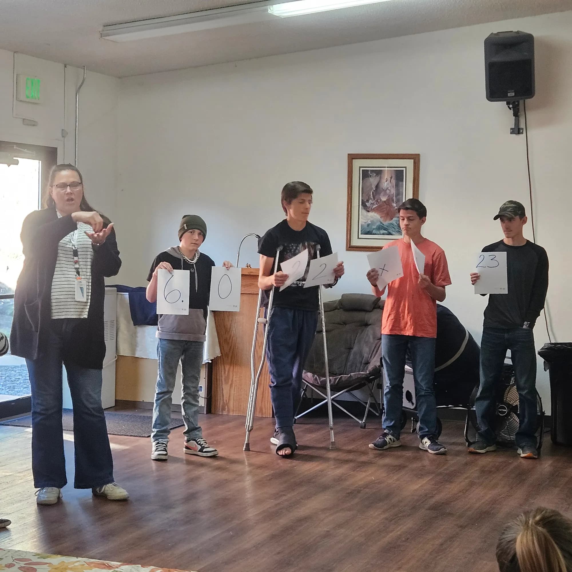 SPRUCE high schoolers hold up cards spelling Avogadro's number while a teacher explains.